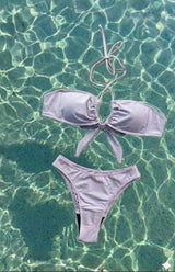 Lavender bikini set floating on clear blue water
