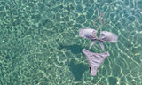 Lavender bikini set floating in clear blue water
